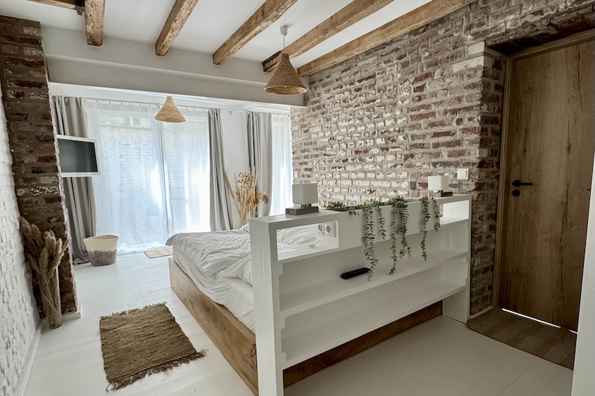 Bett im unteren Schlafzimmer mit Glasfront zum eigenen Innenhof