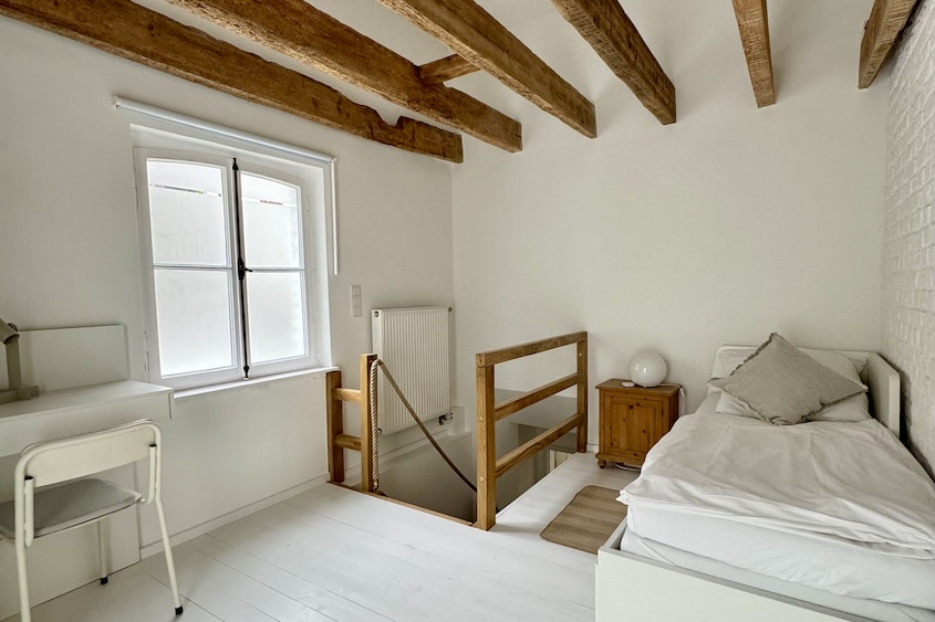 Ansicht des oberen Schlafzimmers, links der Schreibtisch, rechts das Bett, mittig die Treppe nach unten