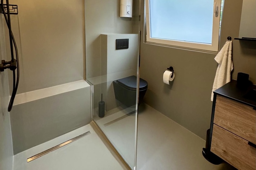 modernes Badezimmer mit Glasdusche, dunkelgrau gestrichen, schwarze Armaturen